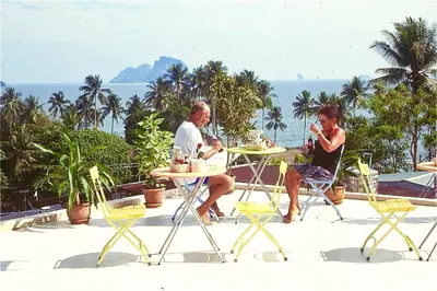 two people sitting at a table near the ocean at J Mansion in Ao Nang Beach