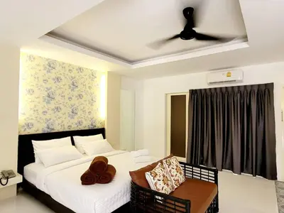 a bedroom with two beds and a ceiling fan at Surintra Boutique Resort in Surin Beach