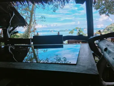 a laptop sitting on a table with a view of the ocean at Tha Khao Bay View Bungalow in Ko Yao Noi
