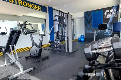 a gym with treadmills and machines in a room at Amata Patong in Patong Beach