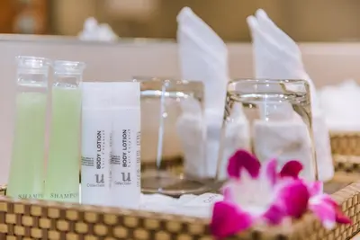 a table with two glasses and a basket with flowers at ASHLEE Hub Hotel Patong in Patong Beach