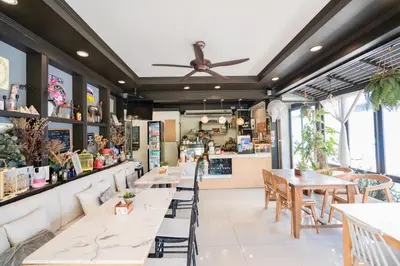 a restaurant with tables and chairs and a counter at The Panwa Guesthouse, Phuket in Panwa Beach