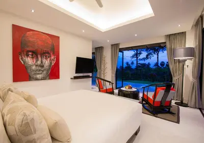 a bedroom with a white bed and a large painting on the wall at Bungalow VILLA Rumba in Ko Yao Noi