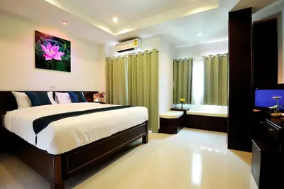 a bedroom with a large bed and a television at Ruen Buathong Boutique Hotel Patong Beach in Patong Beach