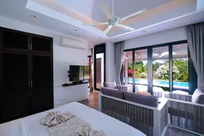 a bedroom with a bed and a living room at Bungalow VILLA Cha Cha in Ko Yao Noi