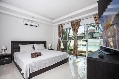 a bedroom with a bed and a flat screen tv at ViLLa JUNGLE 3 BEDROOMS in Kamala Beach