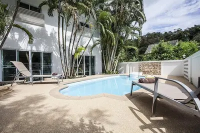 a swimming pool in front of a house at ViLLa JUNGLE 3 BEDROOMS in Kamala Beach