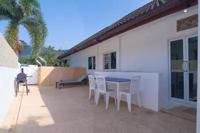a patio with a table and chairs next to a house at JUNGLE APARTMENT2 BEDROOMS PRIVATE POOl in Kamala Beach