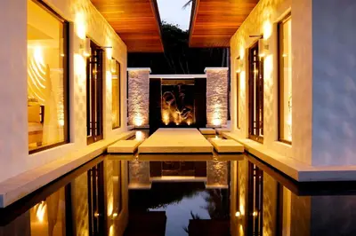 a swimming pool in the middle of a house with lights at The Racha in Ko Racha Yai