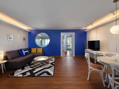 a living room with a couch and a blue wall at Homm Bliss Southbeach Patong in Patong Beach