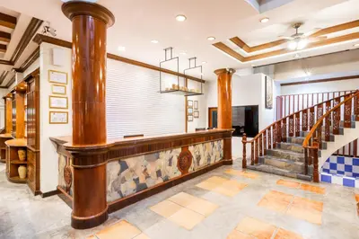 a lobby with a staircase and a large window at Tony Resort in Patong Beach