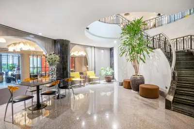 a lobby with a table and chairs and stairs at I Pavilion Hotel Phuket in Phuket Town