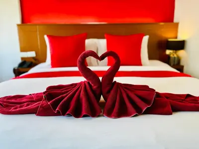 two swans making a heart shape on a bed at PJ Patong Resortel in Patong Beach