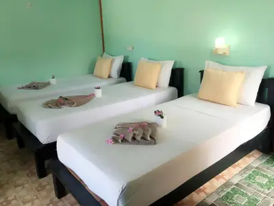 two beds in a room with towels on them at Golden Hill Guesthouse in Phi Phi Don