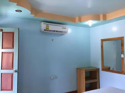 a bedroom with a blue wall with a air conditioner at Golden Hill Guesthouse in Phi Phi Don
