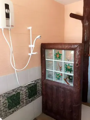 a bathroom with a shower with a glass door at Golden Hill Guesthouse in Phi Phi Don