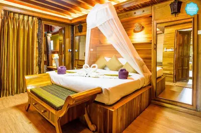 a bedroom with a bed and a chair in a room at Baan Habeebee Resort in Ao Nang Beach