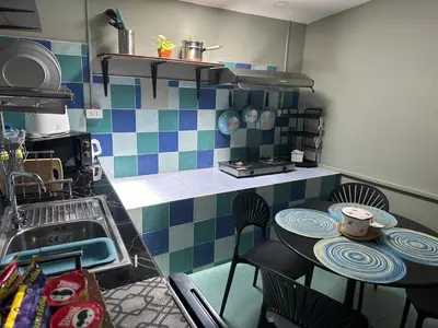 a kitchen with a sink and a table with chairs at Kata Leaf Resort Phuket - in Kata Beach