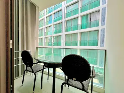 two chairs and a glass table in front of a window at Oceanstone by RESAVA in Bang Tao Beach