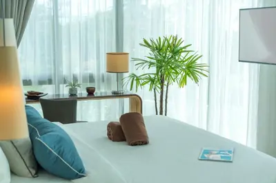 a bedroom with a bed with two towels on it at Oceanstone by RESAVA in Bang Tao Beach