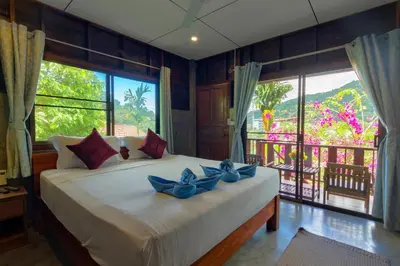 a bedroom with a bed with blue flowers on it at Kanya Cozy Bungalows Kata in Kata Beach