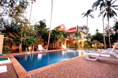 a swimming pool with lounge chairs and a house at Aonang Lake Side in Ao Nang Beach
