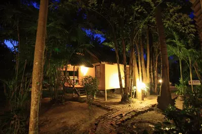 a house with a table and palm trees at night at Aonang Lake Side in Ao Nang Beach