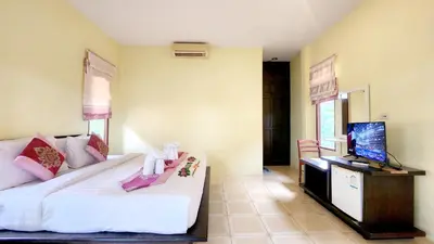 a bedroom with a large bed and a television at Sawaddee Aonang Resort in Ao Nang Beach
