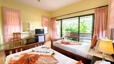 a bedroom with two beds and a large window at Sawaddee Aonang Resort in Ao Nang Beach