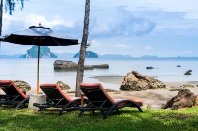 a group of chairs and an umbrella on a beach at Krabi Home Resort in Tab Kaek Beach