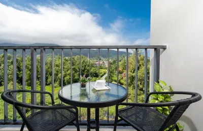 a table and chairs on a balcony with a view at ZcapeX2 in Bang Tao Beach