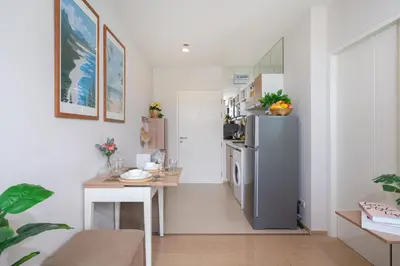 a small kitchen with a refrigerator and a table at ZcapeX2 in Bang Tao Beach