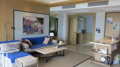 a living room with a blue couch and tables at 5* 3BR SUITE in Amari Phuket - Patong Beach in Patong Beach