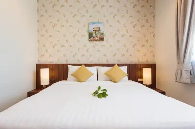 a bedroom with a large white bed with two lamps at Penthouse Savoye in Ao Nang Beach