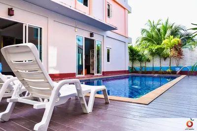a pair of chairs sitting next to a swimming pool at The Orange City Resort in Ao Nang Beach