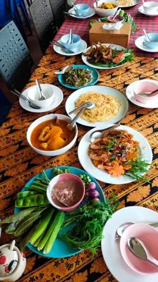 a table with many plates of food on it at Baansuan Amaleena in Ko Yao Noi