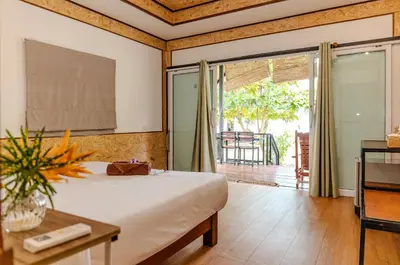 a bedroom with a bed and a sliding glass door at Sunrise House in Ko Yao Noi