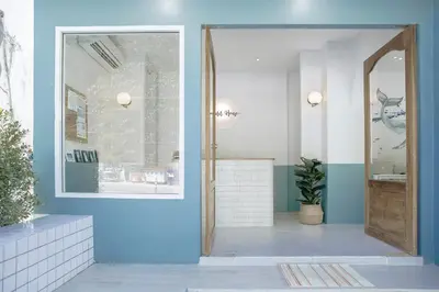 a hallway with a blue wall and a glass door at Wynn House in Karon Beach