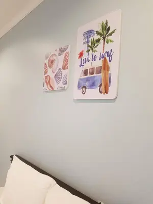 two posters hanging on a wall above a bed at Wynn House in Karon Beach