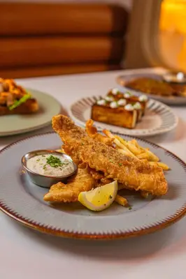 a plate of food with fish and french fries at The Lantern Resorts Patong in Patong Beach