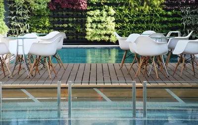 a table and chairs next to a pool at The Lantern Resorts Patong in Patong Beach