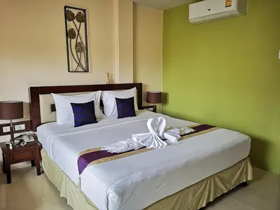 a bedroom with a large bed with towels on it at Seven Seas Hotel Patong Beach in Patong Beach
