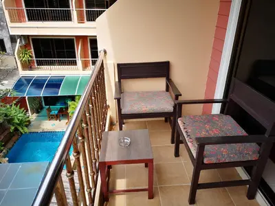 a balcony with two chairs and a table at Seven Seas Hotel Patong Beach in Patong Beach