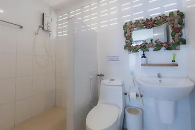 a bathroom with a toilet and a sink and a mirror at Phi Phi Cozy Seafront Resort in Phi Phi Don