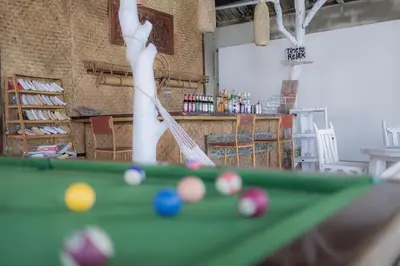 a man playing pool with a cue on a table at Phi Phi Cozy Seafront Resort in Phi Phi Don