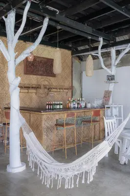 a white hammock in a room with a bar at Phi Phi Cozy Seafront Resort in Phi Phi Don
