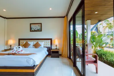 a bedroom with a bed and a balcony at Airport Resort Phuket in Nai Yang Beach