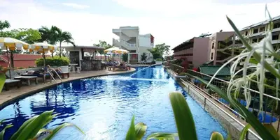a large swimming pool in a city with buildings at Karon Princess Hotel SHA EXTRA Plus in Karon Beach