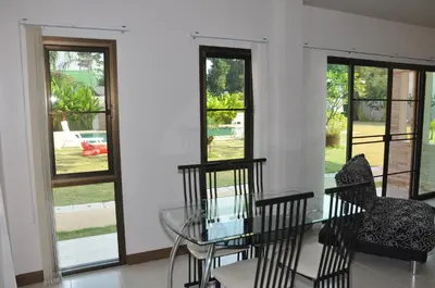 a dining room with a glass table and chairs and windows at Babylon Pool Villas in Nai Harn Beach