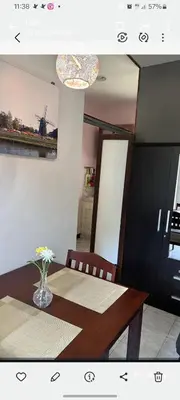 a dining room table with a vase of flowers on it at Studio with aircon n kitchen in Bang Tao Beach
